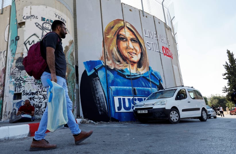 A Palestinian walks in front of a mural depicting the slain Palestinian-American journalist Shireen Abu Akleh ahead of the visit of US President Joe Biden at Bethlehem in the Israeli-occupied West Bank, July 13, 2022. (photo credit: REUTERS\Mussa Qawasma)