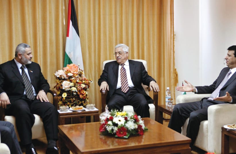  MOHAMMED DAHLAN (right) attends a meeting with Palestinian Authority head Mahmoud Abbas of Fatah and then-prime minister Ismail Haniyeh of Hamas, in Gaza, April 2007, a couple of months before the Hamas overthrow of the PA in the Strip.  (photo credit: MOHAMMED SALEM/REUTERS)