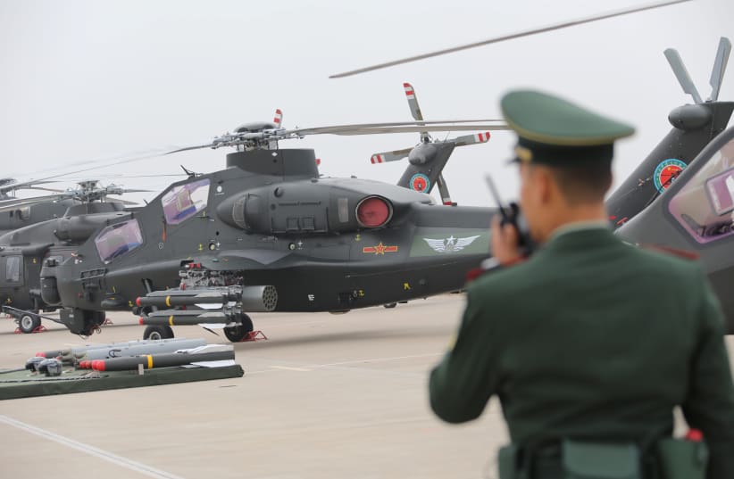A military personnel speaks on his walkie-talkie before a military helicopter from Chinese People's Liberation Army (PLA) Air Force during the China Helicopter Exposition in Tianjin, China October 10, 2019. Picture taken October 10, 2019. (photo credit: REUTERS/STRINGER)