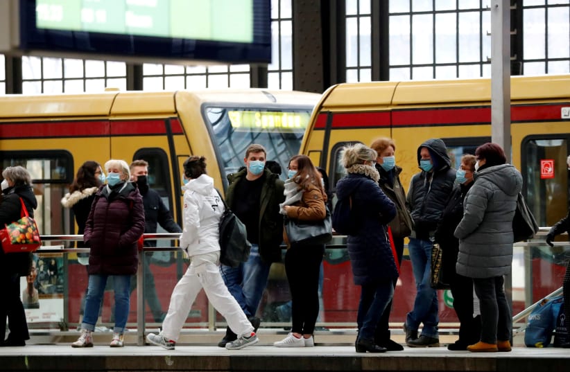  Passengers wear face masks as they wait for an S-Bahn commuter train on the platform at Friedrichstrasse station during lockdown amid the coronavirus disease (COVID-19) pandemic, in Berlin, Germany February 5, 2021 (photo credit: Fabrizio Bensch/Reuters)
