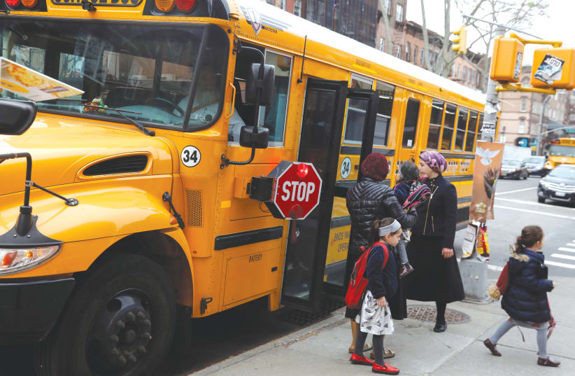  CHILDREN GET OFF a yeshiva school bus in the Williamsburg neighborhood of Brooklyn. (photo credit: Shannon Stapleton/Reuters)