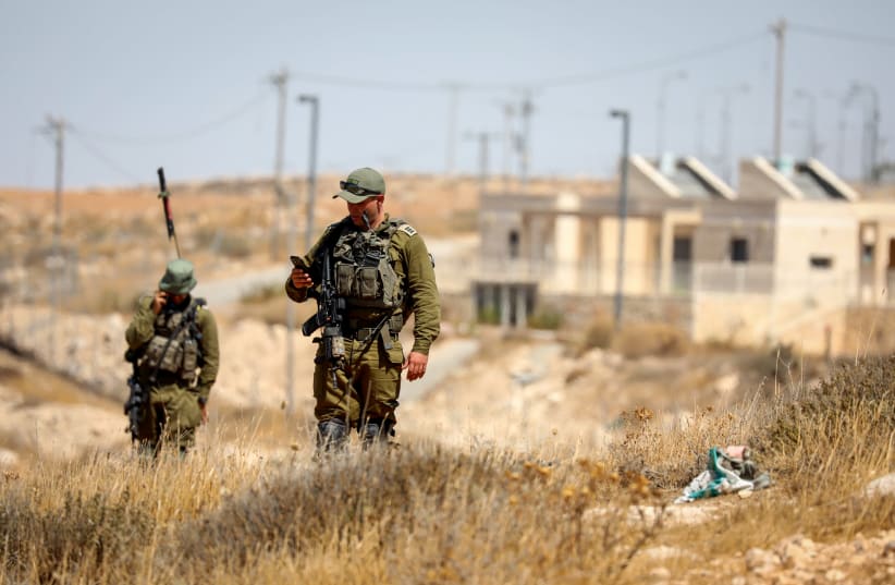  Israeli soldiers guard in the area where Palestinian carried out a shooting attack last night south of Hebron, in the West Bank on September 16, 2022 (photo credit: WISAM HASHLAMOUN/FLASH90)