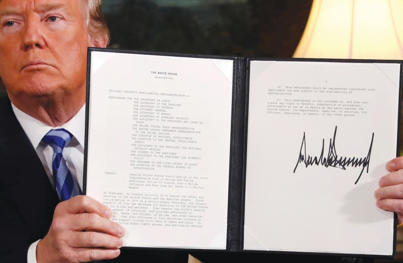  HEN-US president Donald Trump holds up a proclamation declaring his intention to withdraw from the Iran nuclear agreement, in 2018 (photo credit: REUTERS)