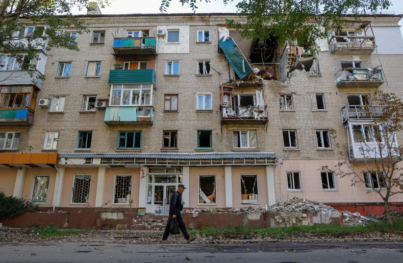  A man walks past a residential building damaged in the course of Russia-Ukraine conflict in Lysychansk, the city controlled by pro-Russian troops in the Luhansk region, Ukraine September 21, 2022.  (photo credit: REUTERS/ALEXANDER ERMOCHENKO)