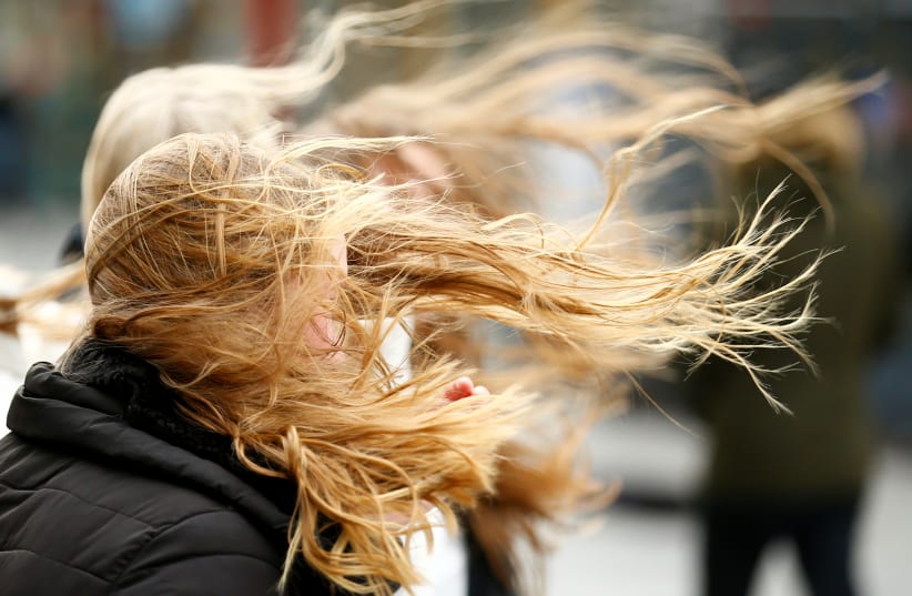  People walk through strong gusts of wind as storm Sabine is expected to hit the region in Cologne, Germany (photo credit: REUTERS)