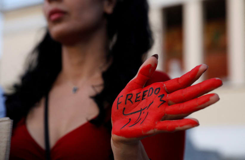  A woman with her hand painted with the word "Freedom" takes part in a protest following the death of Mahsa Amini, in Athens, Greece, October 1, 2022 (photo credit: REUTERS/COSTAS BALTAS)