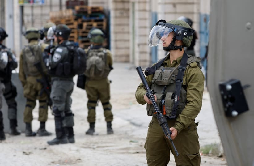  Israeli forces stand guard during clashes with Palestinians following the funeral of Palestinian Osama Adawy, 18, who was killed by Israeli troops during clashes on Wednesday, in Al Aroub camp in the West Bank, October 13, 2022. (photo credit: REUTERS/MUSSA QAWASMA)