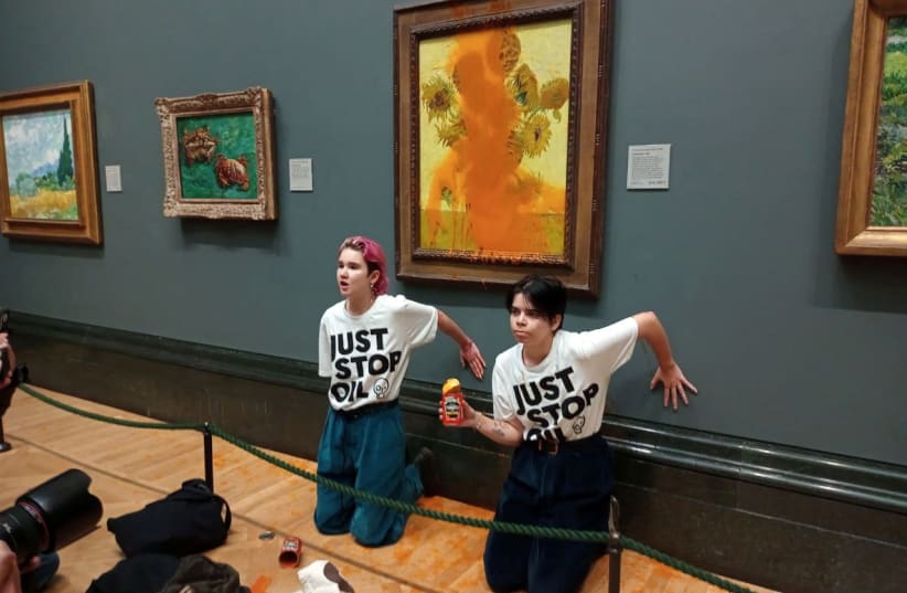  Activists of "Just Stop Oil" glue their hands to the wall after throwing soup at a van Gogh's painting "Sunflowers" at the National Gallery in London (photo credit: Just Stop Oil/Handout via REUTERS)