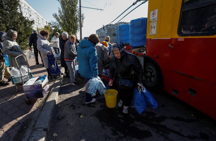  Local people queue to fill up bottles with fresh drinking water, as the main supply pipeline for drinking water for the city was damaged in Kherson region at the beginning of Russia's attack on Ukraine, in Mykolaiv, Ukraine October 16, 2022 (photo credit: VALENTYN OGIRENKO/REUTERS)