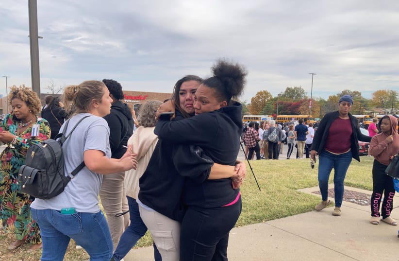  People embrace following a shooting at a high school, in St. Louis, United States, October 24, 2022. (photo credit: Holly Edgell/NPR Midwest Newsroom/ via REUTERS)