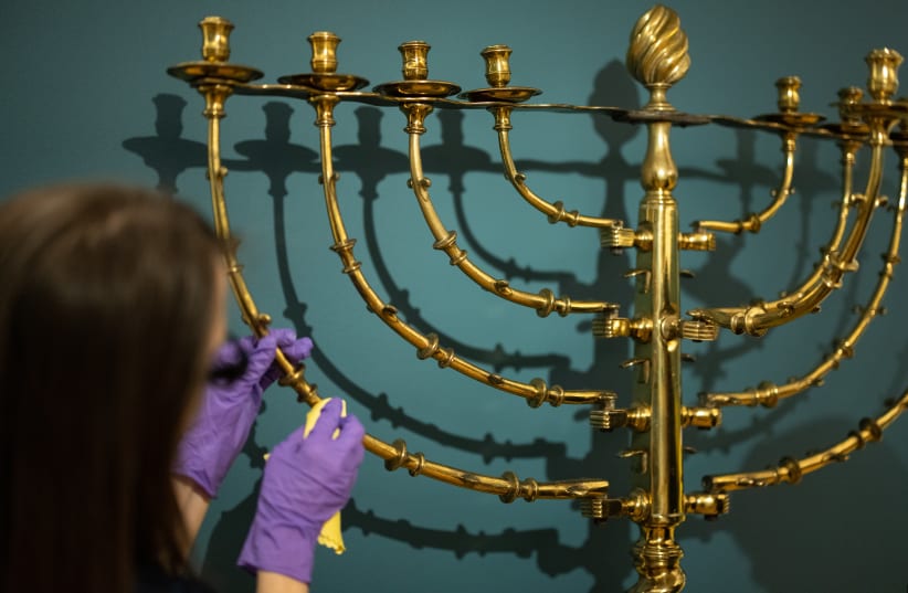  Members of the museum team clean an early 18th-century menorah at the Jewish Museum in London.  (photo credit: Leon Neal/Getty Images)