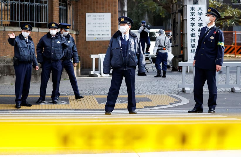  Police officers inspect the site where a stabbing incident happened at an entrance gate of Tokyo University in Tokyo, Japan January 15, 2022 (photo credit: REUTERS/ISSEI KATO)