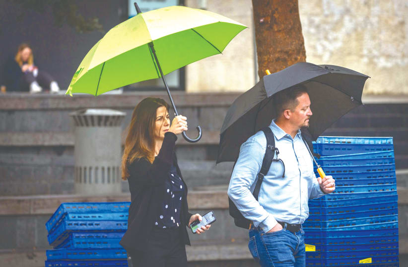  BRAVING THE rain in Jerusalem this week: Because the current month is the beginning of the rainy season and the prayers for rain, its name appears numerous times in rabbinic literature (photo credit: OLIVIER FITOUSSI/FLASH90)