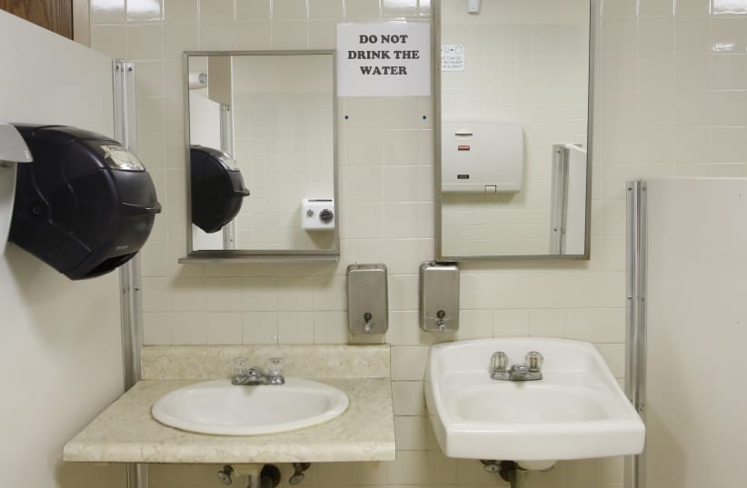  A sign warns against drinking the water in the men's restroom at the Thousand Islands welcome center in Orleans, New York, February 23, 2016. (photo credit: REUTERS/CHRIS WATTIE)