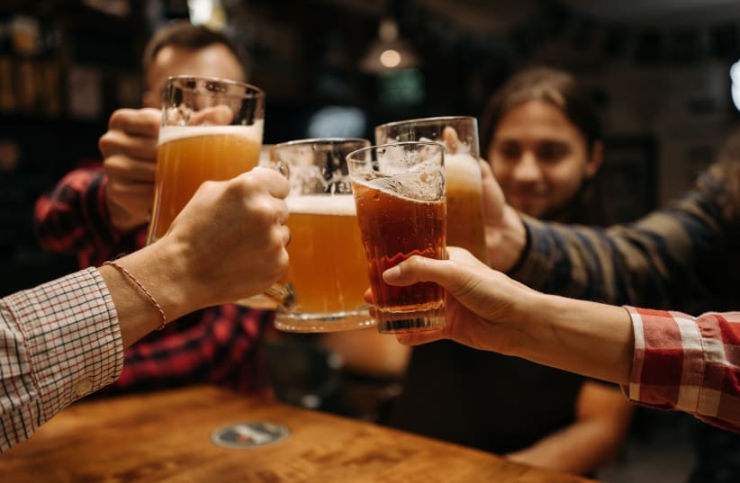 People drinking beer in a group  (photo credit: PEXELS)