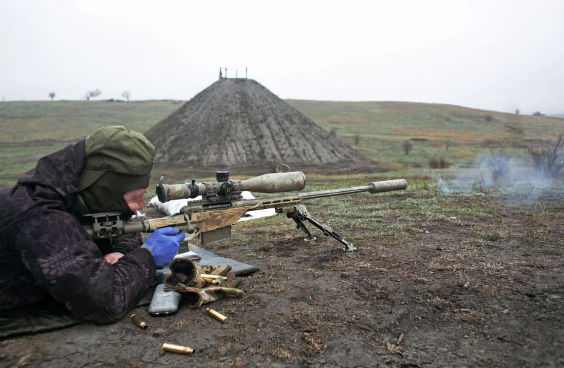  A sniper of the Ukrainian armed forces fires his rifle during training at a firing range near the town of Marinka in Donetsk region, Ukraine April 13, 2021. (photo credit: Anastasia Vlasova/Reuters)