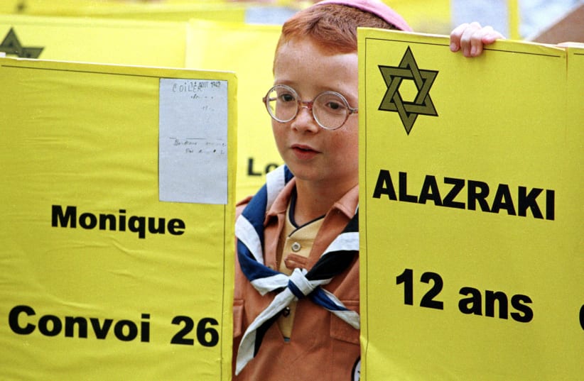 A young Jewish boy holds yellow signs bearing the names of jews who were deported from Bordeaux to Nazi death camps in World War II. The demonstration took place in front of a synagogue, October 8 coinciding with the opening of the trial of Maurice Papon, an ex-cabinet minister, charged with crimes (photo credit: REUTERS)