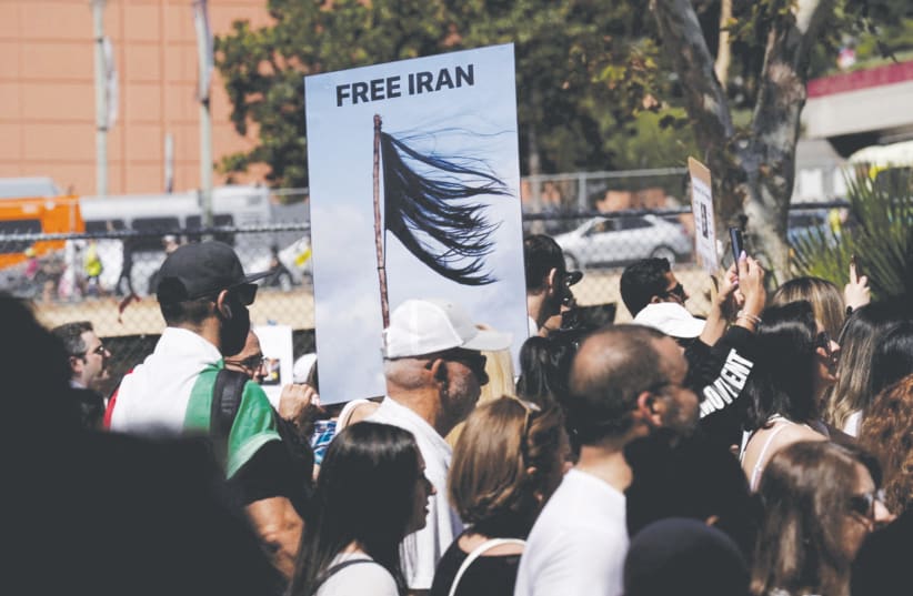  DEMONSTRATORS HOLD a ‘Free Iran’ sign, in Los Angeles last month, depicting a shorn hair, protesting in support of Iranian women and against the death of Mahsa (Zhina) Amini. On November 3, President Joe Biden argued the United States would free Iran (photo credit: REUTERS)
