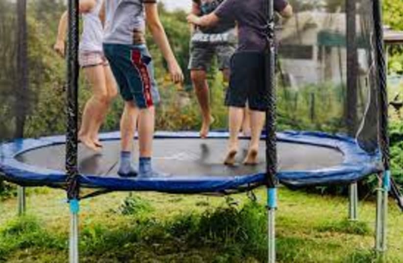  Kids on a trampoline. (photo credit: PEXELS)