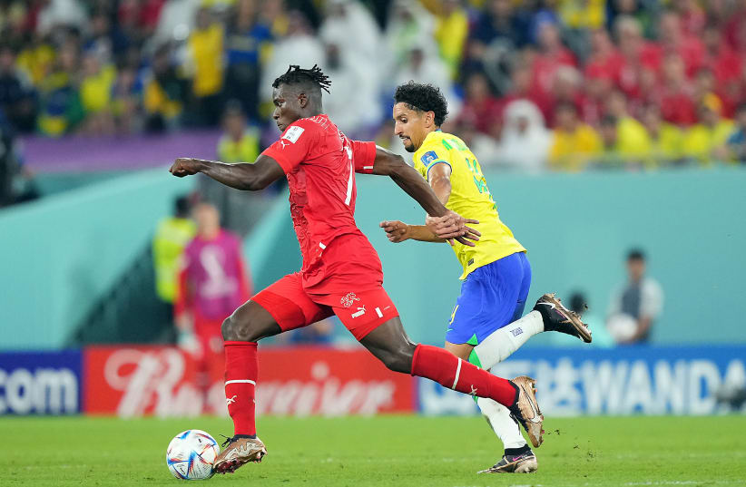  SWITZERLAND FORWARD Breel Embolo (L) moves the ball ahead of Brazil defender Marquinhos in the second half of a group stage match during the 2022 World Cup in Doha, Qatar.  (photo credit: Danielle Parhizkaran/USA TODAY Sports)
