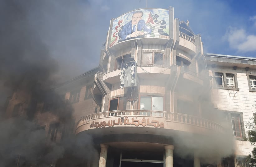  Smoke rises near a building as people take part in a protest in Sweida, Syria, December 4, 2022, in this picture obtained by Reuters. (photo credit: Suwayda 24/via REUTERS)