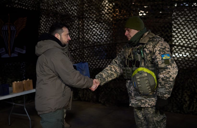  Ukraine's President Volodymyr Zelensky awards a service member at a position near a frontline on the Day of the Ukrainian Armed Forces, amid Russia's attack on Ukraine, in Donetsk region, Ukraine December 6, 2022. (photo credit: Ukrainian Presidential Press Service/Handout via REUTERS)
