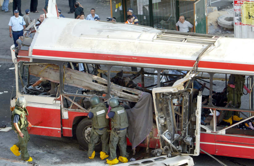  Emergency workers inspect the wreckage of a bus after a suspected suicide bomb attack in Jerusalem June 11, 2003 (photo credit: REUTERS/GIL COHEN MAGEN)