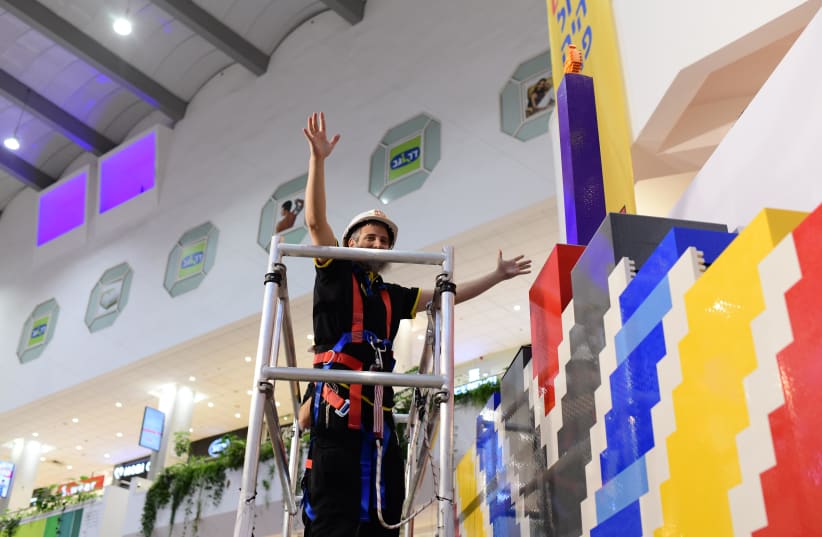  Master builder Yitzy Kasowitz who came especially from the USA and volunteers breaking the Guinness record for building a menorah from Lego that consists of 130,000 Lego blocks and 4 meters high and 4 meters wide, in Tel Aviv, on December 12, 2022.  (photo credit: TOMER NEUBERG/FLASH90)