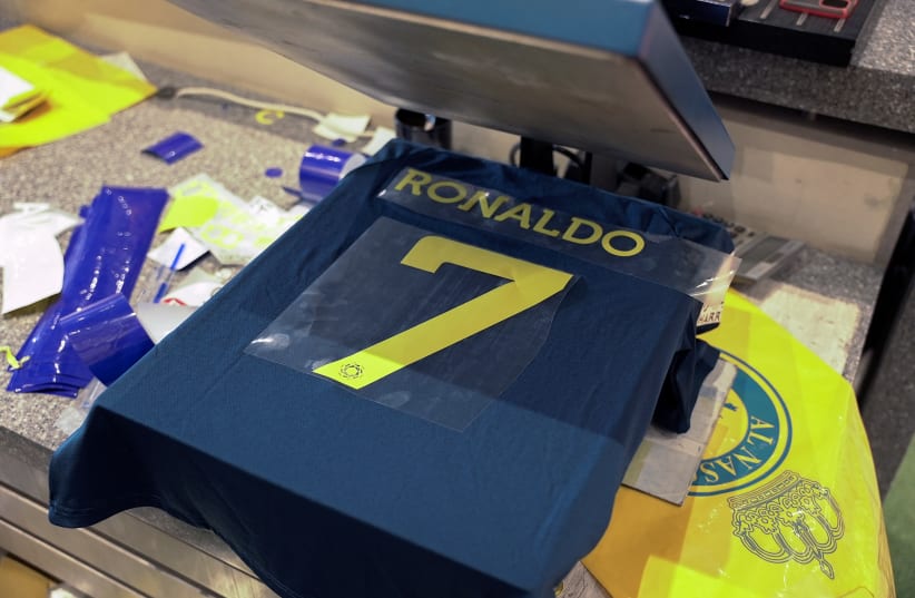 A general view of an Al Nassr soccer jersey and Cristiano Ronaldo's surname and number on a heat press, after it was announced the player has signed a contract with the club, in Riyadh, Saudi Arabia December 31, 2022. (photo credit: REUTERS/MOHAMMED BENMANSOUR)