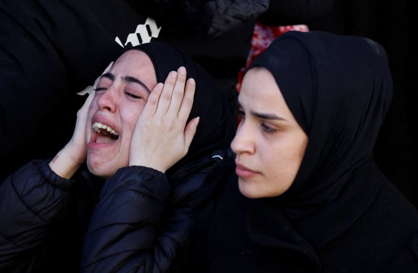 The daughter of 57-year-old teacher Jawad Bouaqneh reacts as mourners carry his and 28-year-old militant Adham Jabbarin bodies during their funeral, in Jenin, in the West Bank January 19, 2023.  (photo credit: MOHAMAD TOROKMAN/REUTERS)