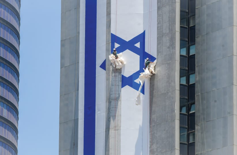  THEY DO not fly the Blue and White: Hanging the flag in Ramat Gan. (photo credit: AVSHALOM SASSONI/FLASH90)
