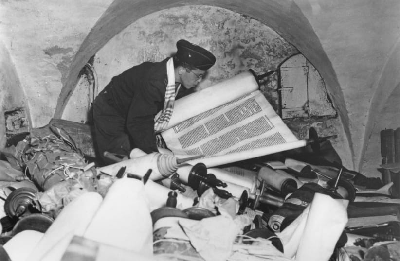  TORAH DEALS only with the ‘why’: US Army chaplain examines one of hundreds of Torah scrolls stolen from all over Europe by Nazi forces, in Frankfurt, Germany, 1945. (photo credit: Irving Katz/US Army Signal Corps/FPG/Hulton Archive/Getty Images)