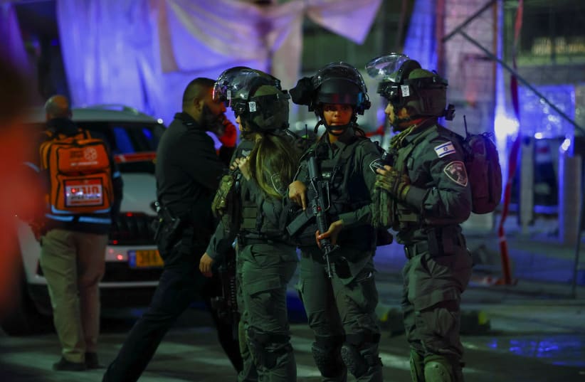  Israeli forces stand guard near the scene of a terror attack in Neve Yaakov in which at least 7 people were killed, January 27, 2022. (photo credit: REUTERS/Ronen Zvulun)