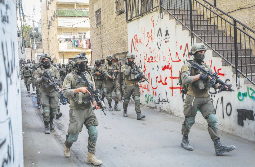  ISRAELI SECURITY forces are seen walking through the Shuafat refugee camp in Jerusalem last week after the government demolished the house of a Palestinian terrorist who was behind an attack that took place last year. (photo credit: JAMAL AWAD/FLASH90)