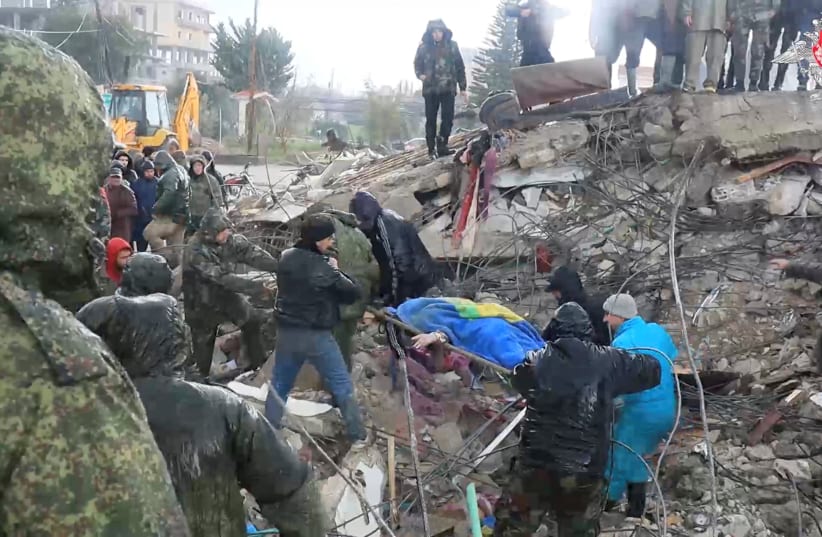  A still image from video, released by Russia's Defence Ministry, shows people including Russian military personnel involved in a search and rescue operation after a devastating earthquake in the region of Latakia, Syria, in this image taken from handout footage released February 7, 2023. (photo credit: Russian Defence Ministry/Handout via REUTERS)