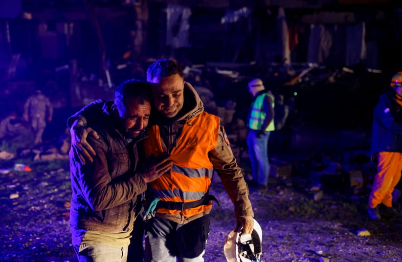 Volunteers share an emotional moment as they take part in a rescue operation following an earthquake in Hatay, Turkey February 8, 2023. (photo credit: REUTERS/KEMAL ASLAN)