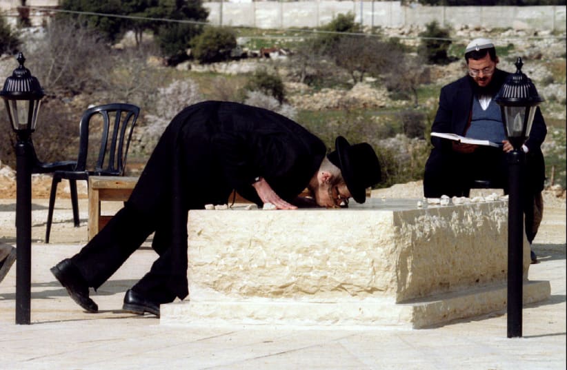  An ultra-orthodox Jew, in 1995, kisses the tombstone of Baruch Goldstein, the Israeli settler who in 1994 shot and killed 29 Palestinians as they prayed in a mosque in Hebron (photo credit: REUTERS)