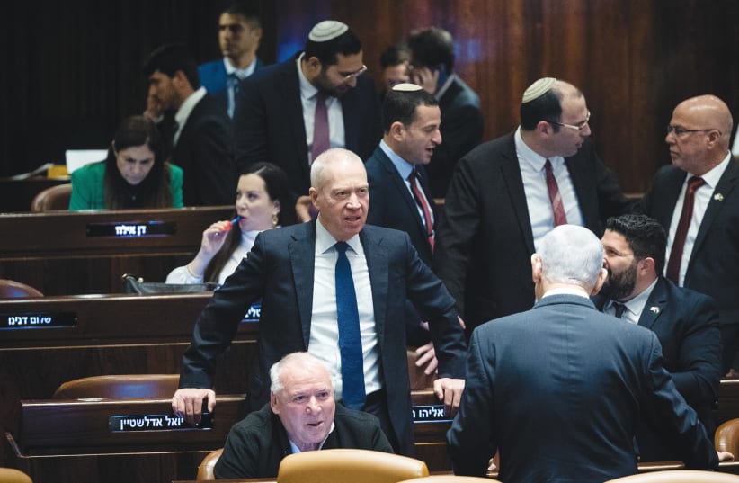  DEFENSE MINISTER Yoav Gallant stands in the center amid a flurry of activity among coalition members in the Knesset plenum, last week. The time has come for Gallant to take charge as the responsible adult, says the writer.  (photo credit: YONATAN SINDEL/FLASH90)