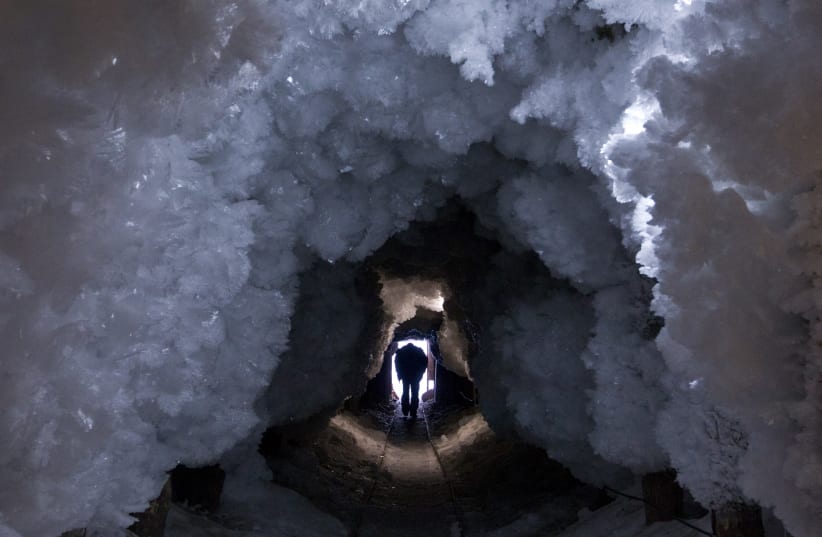 A man walks through a tunnel formed from crystals of permafrost outside the village of Tomtor in the Oymyakon valley in northeast Russia, January 28, 2013. (photo credit: REUTERS/MAXIM SHEMETOV)