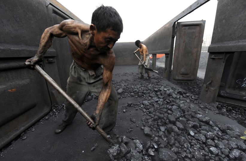  Workers unload coal at a storage site along a railway station in Hefei, Anhui province in China, October 27, 2009. (photo credit: Jianan Yu/Reuters)