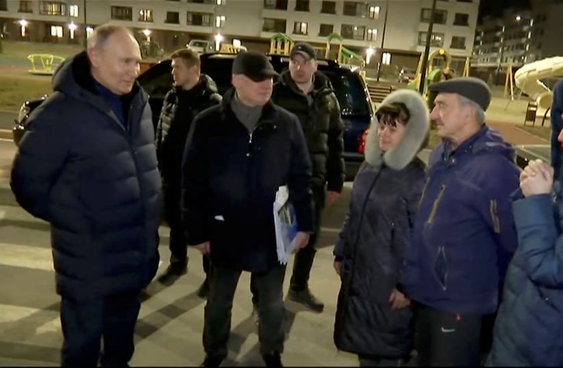 Russian President Vladimir Putin listens to local residents as he visits Mariupol, Russian-controlled Ukraine, in this still image taken from handout video released on March 19, 2023. (photo credit: KREMLIN.RU/HANDOUT VIA REUTERS)