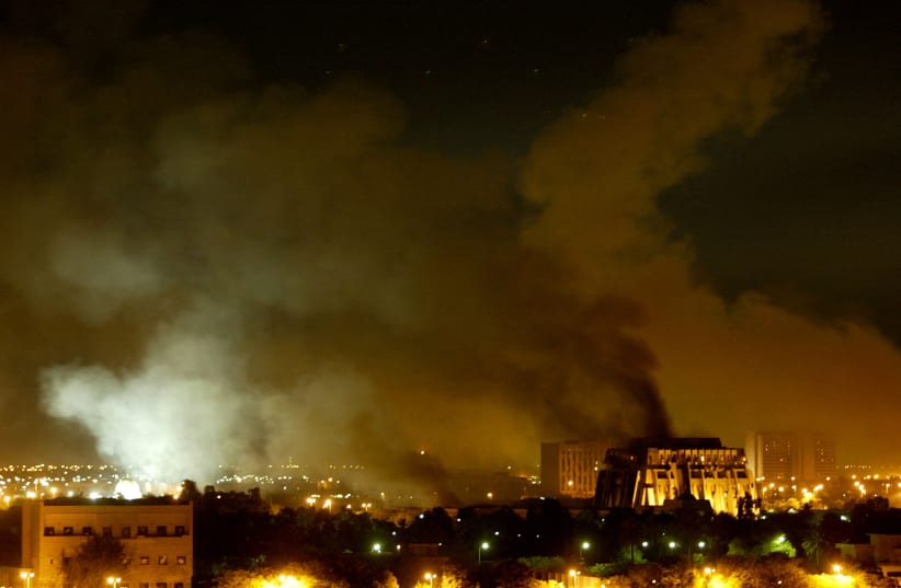Smoke billows from a presidential palace compound in Baghdad during airstrikes, Iraq, March 21, 2003. Large explosions shook Baghdad during a night of blistering air strikes, as US and British ground forces advancing across southern Iraq battled for hours for control of a strategic airfield. (photo credit: REUTERS/GORAN TOMASEVIC/FILE PHOTO)