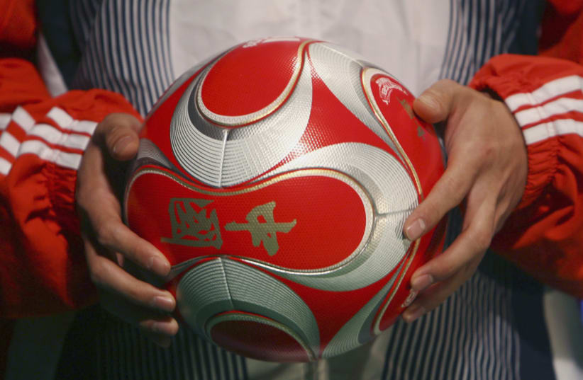  An athlete holds the official ball for the 2008 Beijing Olympics football match during its launching ceremony in Beijing January 26, 2008.  (photo credit: REUTERS/STRINGER)