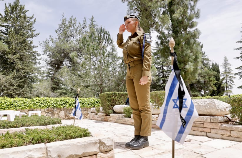  An IDF soldier salutes the grave of a fallen soldier at the Har Herzl military cemetery ahead of Israel's Remembrance Day, April 23, 2023. (photo credit: MARC ISRAEL SELLEM/THE JERUSALEM POST)