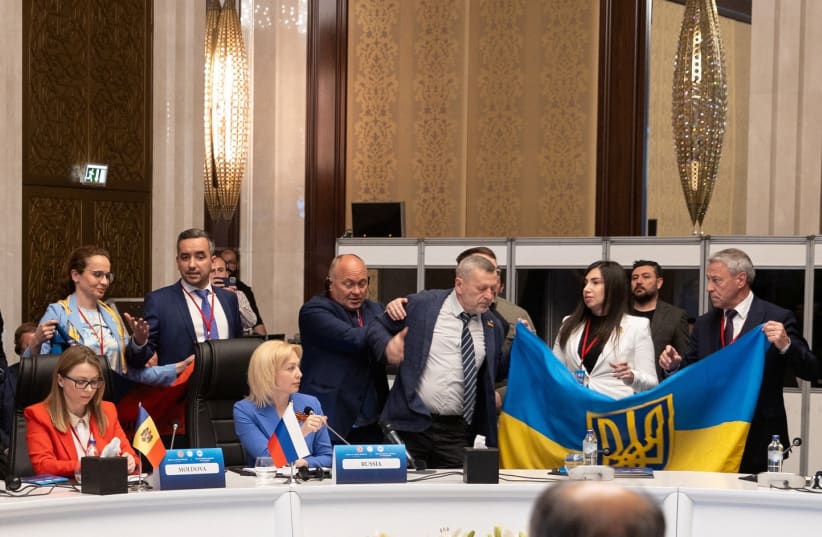  Members of Ukrainian delegation unfurl their national flag next to Olga Timofeeva, deputy head of Russian delegation, to disrupt her speech during a meeting of the Parliamentary Assembly of the Black Sea Economic Cooperation (PABSEC) in Ankara, Turkey May 4, 2023. (photo credit:  Edib Kurt/Turkish Grand National Assembly, TBMM/Handout via REUTERS)
