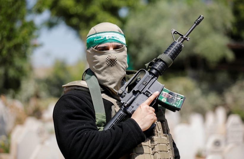  A person holds up a gun during the funeral of two Palestinian Islamic Jihad gunmen who were killed in an Israeli raid, in Jenin refugee camp in the West Bank May 10, 2023. (photo credit: RANEEN SAWAFTA/REUTERS)
