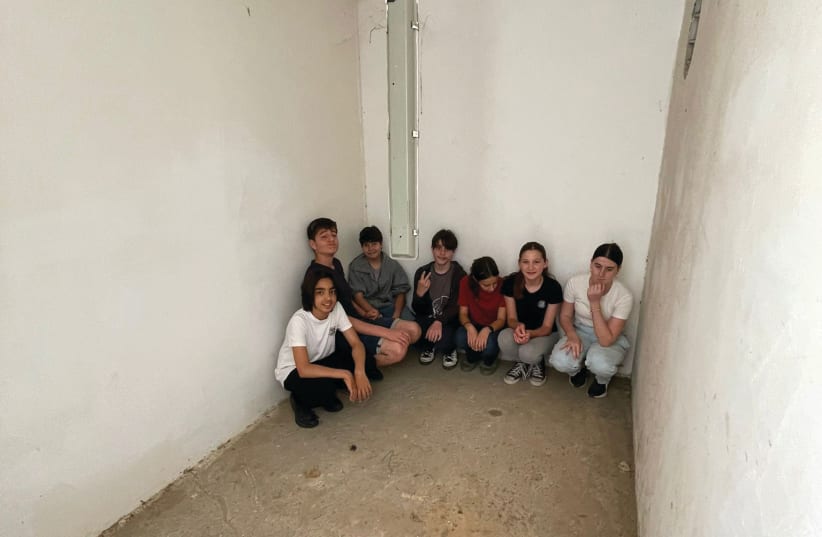  STUDENTS AT Kfar Silver demonstrate how they huddle in a safe room at the youth village when a siren sounds. (photo credit: WORLD ORT)