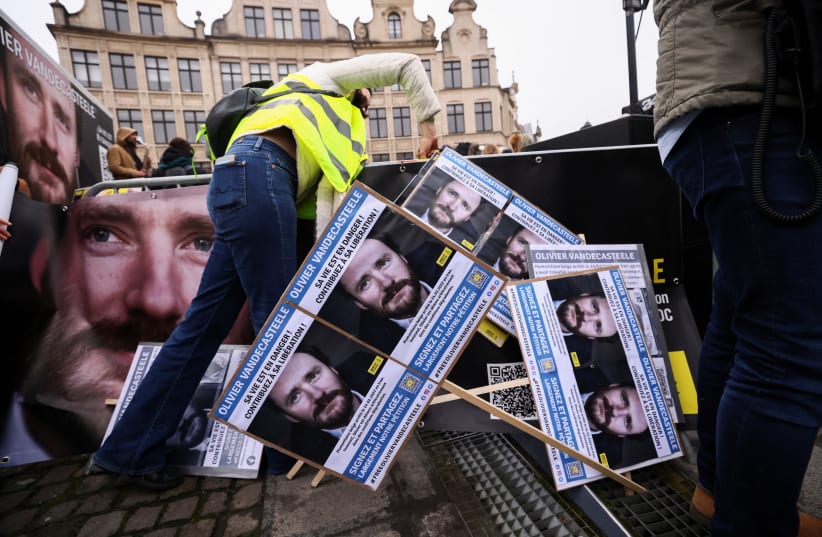 A person arranges placards during a protest against the detention of Belgian aid worker Olivier Vandecasteele in Iran, who was sentenced to 40 years in prison and 74 lashes on charges including spying, in Brussels, Belgium January 22, 2023. (photo credit: YVES HERMAN/REUTERS)