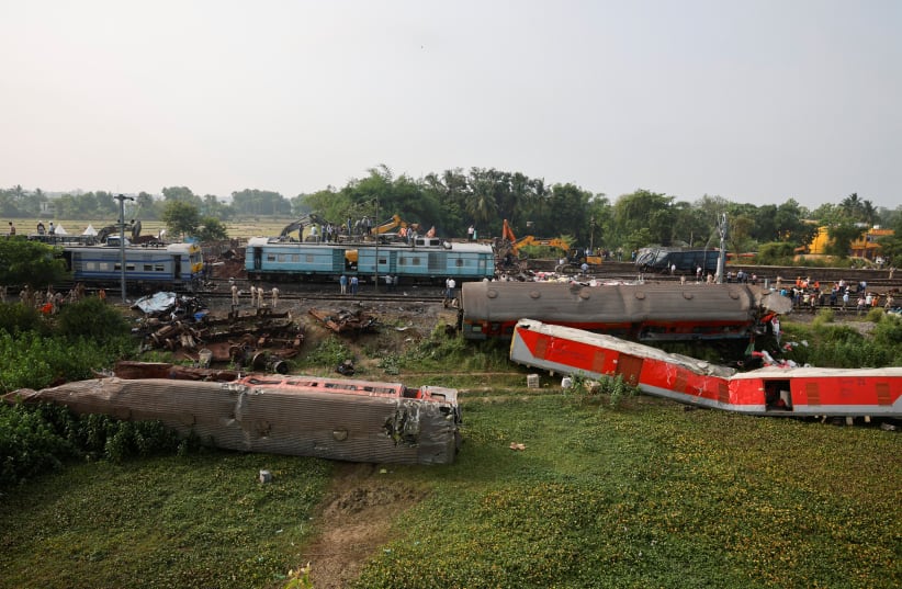  Heavy machinery removes damaged coaches from the railway tracks at the site of a train collision following the accident in Balasore district in the eastern state of Odisha, India, June 4, 2023. (photo credit: REUTERS/ADNAN ABIDI)