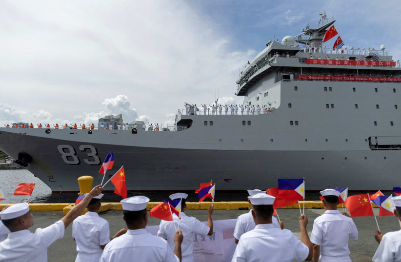  Philippine Navy personnel wave the national flags of China and the Philippines as the Chinese naval training ship "Qi Jiguang" docks at the Port of Manila for a four-day goodwill visit, in Manila, Philippines, June 14, 2023. (photo credit: ELOISA LOPEZ/ REUTERS)